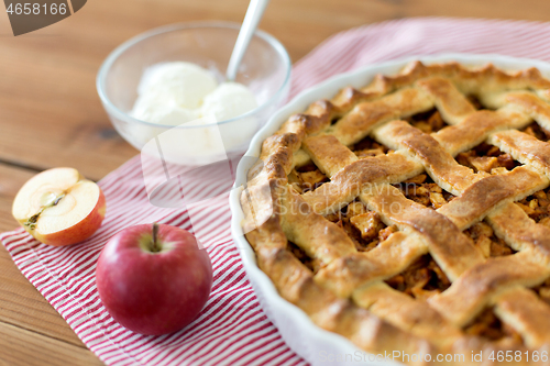 Image of apple pie with ice cream on wooden table