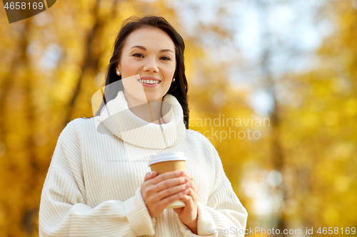 Image of woman drinking takeaway coffee in autumn park