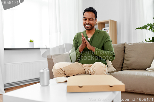 Image of indian man looking inside of takeaway pizza box