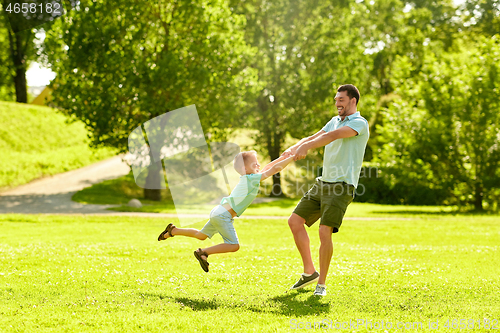 Image of happy father and son having fun at summer park