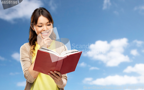 Image of happy asian woman reading book