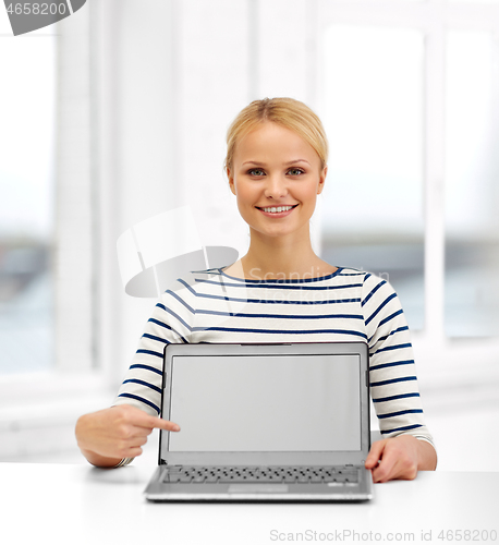 Image of smiling woman with laptop computer at office