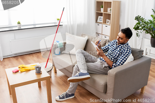 Image of indian man with to do list after home cleaning