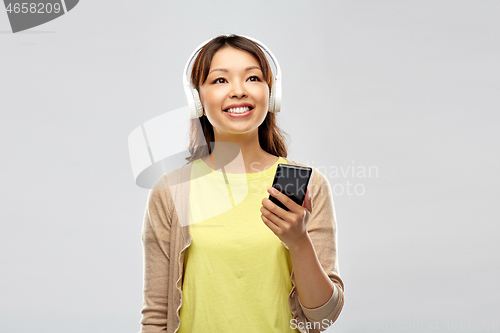 Image of asian woman in headphones listening to music