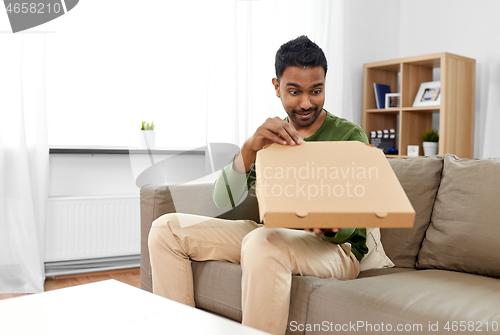 Image of indian man looking inside of takeaway pizza box