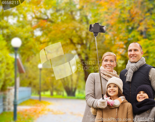 Image of happy family with smartphone and monopod in park