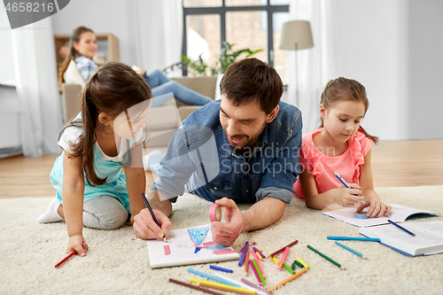 Image of father spending time with little daughters at home