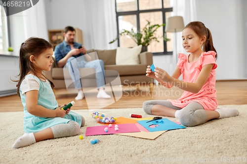 Image of happy sisters doing arts and crafts at home