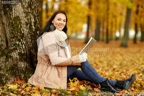 Image of woman reading book at autumn park