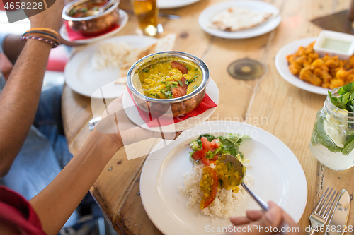 Image of woman eating with friends at restaurant