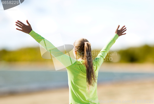 Image of happy woman in sports clothes on beach