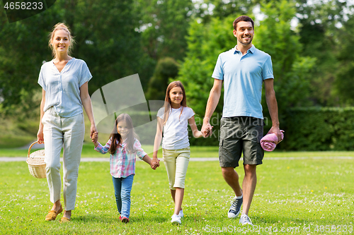 Image of family with picnic basket walking in summer park