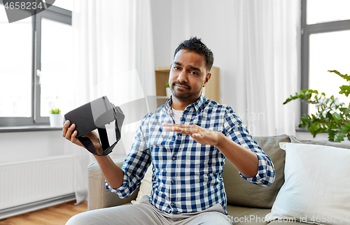 Image of male blogger with vr glasses videoblogging at home