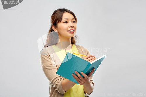 Image of asian student woman with diary and pencil