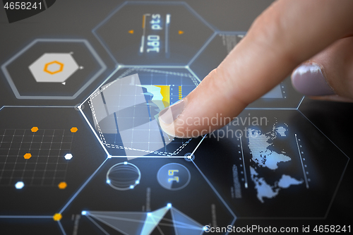 Image of finger on touch screen with virtual charts