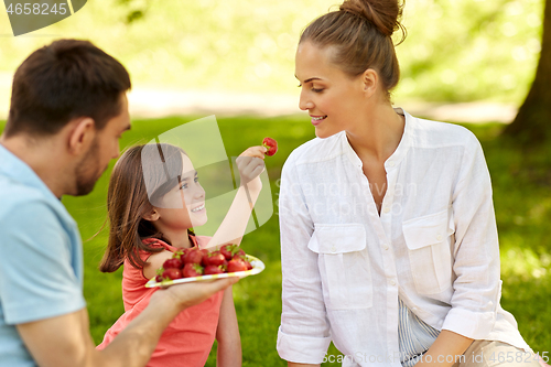 Image of family eating strawberries on picnic at park