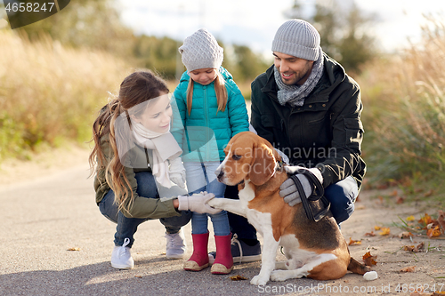 Image of happy family with beagle dog outdoors in autumn