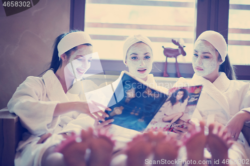 Image of bachelorette party in spa, girls with face mask reading magazine