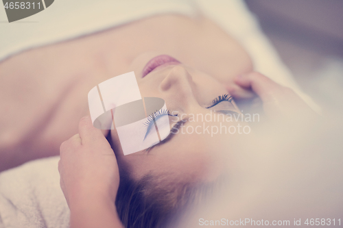 Image of woman getting face and head  massage in spa salon