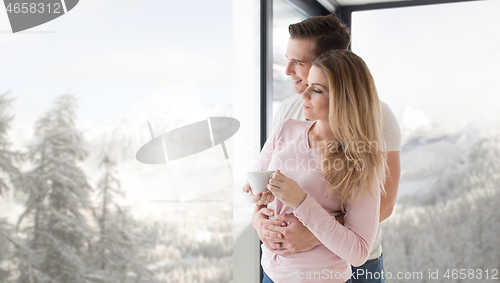 Image of young couple enjoying morning coffee by the window