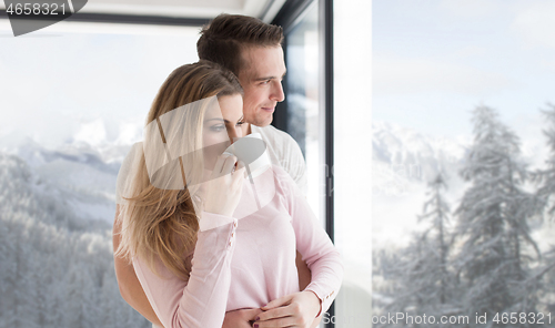 Image of young couple enjoying morning coffee by the window