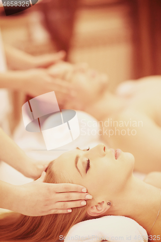 Image of relaxed young couple getting massage in spa