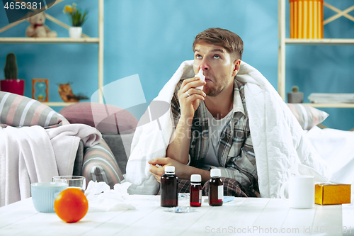 Image of Bearded sick man with flue sitting on sofa at home. Illness, influenza, pain concept. Relaxation at Home. Healthcare Concepts.