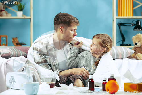 Image of Sick man with daughter at home. The ill family.