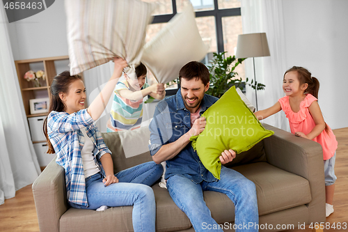 Image of happy family having pillow fight at home