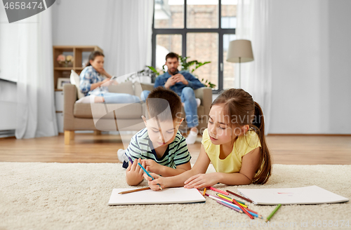 Image of brother and sister drawing with crayons at home