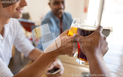 Image of happy male friends drinking beer at bar or pub