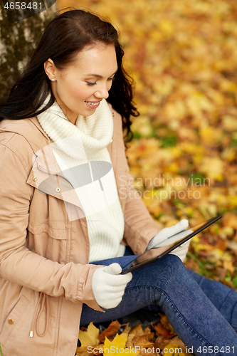 Image of woman with tablet computer at autumn park