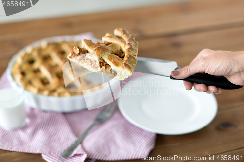 Image of close up of hand with piece of apple pie on knife