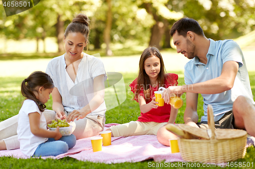 Image of happy family having picnic at summer park