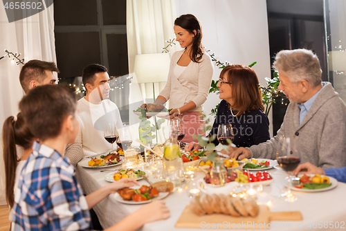 Image of happy family having dinner party at home