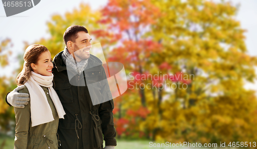 Image of smiling couple hugging in autumn park