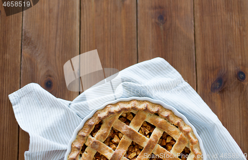 Image of close up of apple pie in mold on wooden table