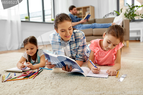 Image of mother spending time with little daughters at home