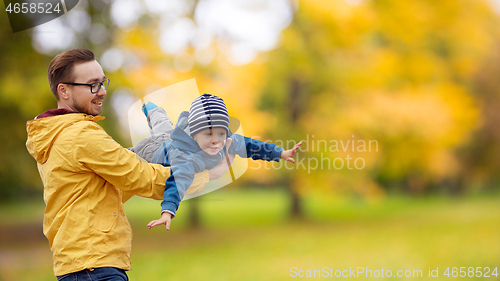 Image of father with son playing and having fun in autumn