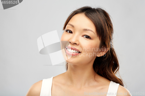 Image of face of happy smiling young asian woman