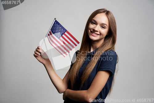 Image of Happy female holding United States flag