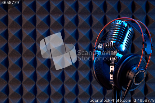 Image of Studio condenser microphone with professional headphones acoustic panel