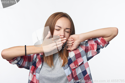 Image of Tired woman yawning covering a mouth with her hand