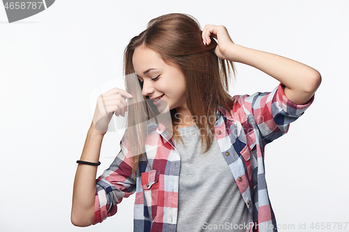 Image of Smiling relaxed teen girl with raised hands looking down,