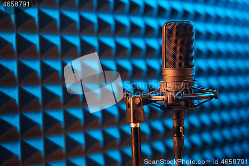 Image of Studio condenser microphone on blue acoustic foam panel background