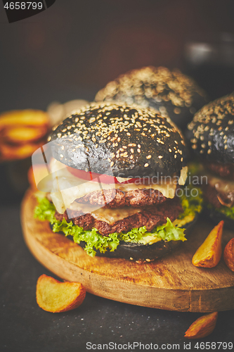 Image of Black double Burgers with Cheese. Cheeseburgers from Japan with black bun on dark background