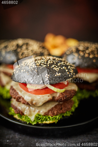 Image of Black double cheeseburger with tomatoes and lettuce