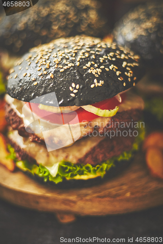 Image of Black double Burgers with Cheese. Cheeseburgers from Japan with black bun on dark background