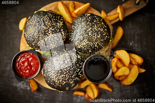 Image of Black burgers and fries with sauce