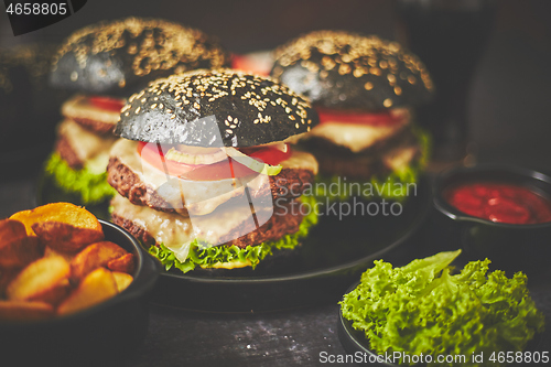 Image of Appetizing black hamburgers and fried potato